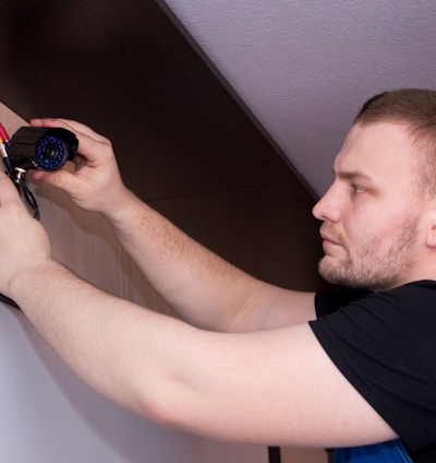 a man working on a wall with a screwdriver