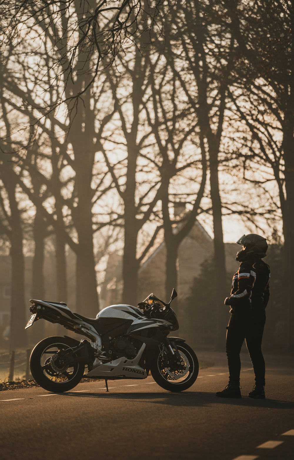 a person standing next to a parked motorcycle