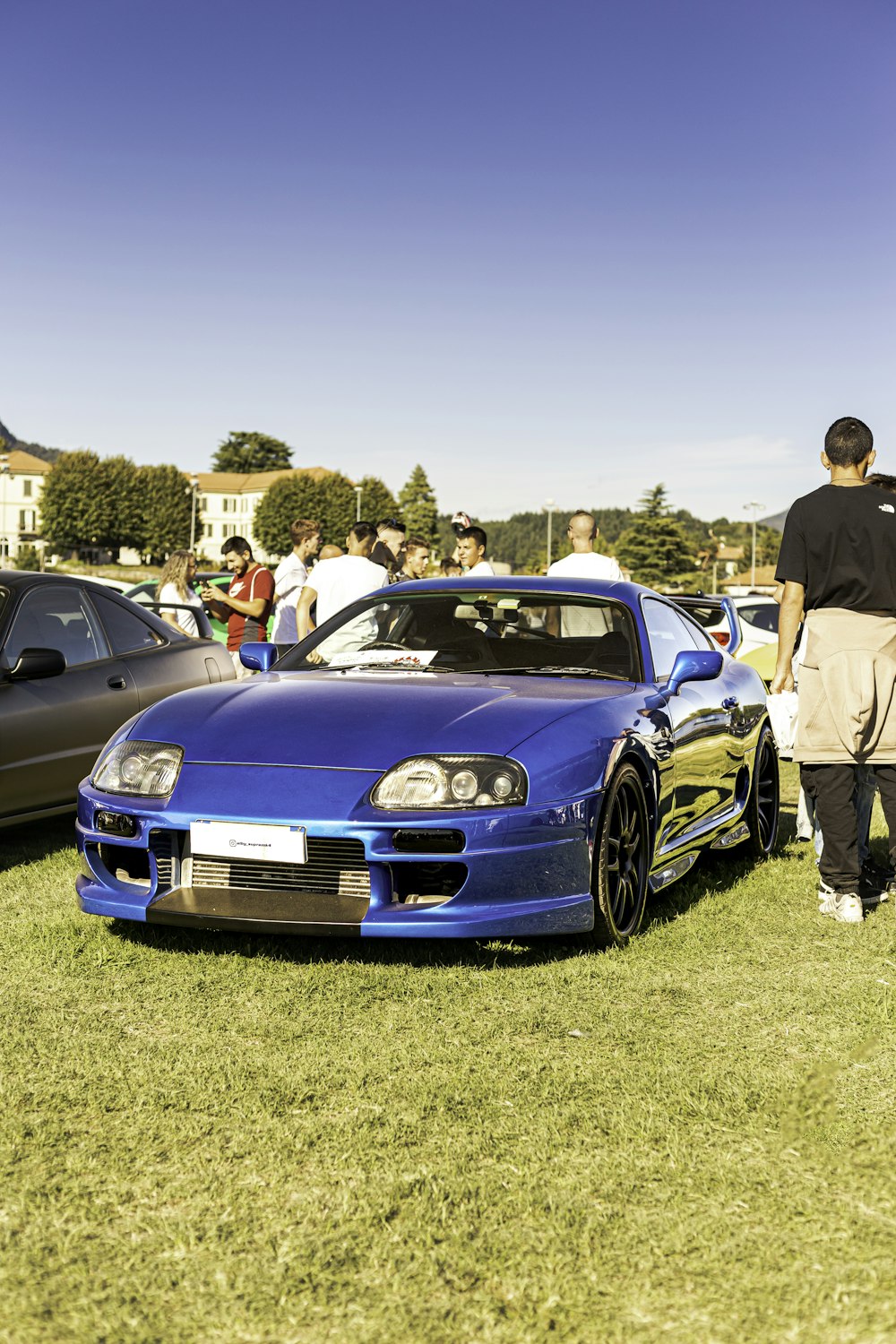 a couple of cars parked next to each other on a lush green field