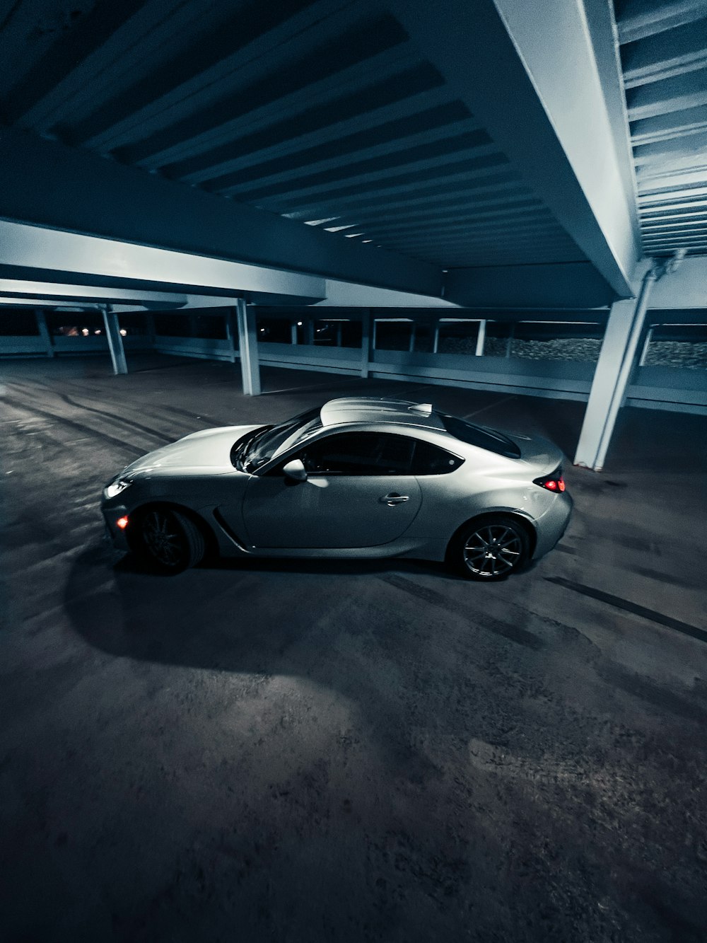 a silver sports car parked in a parking garage