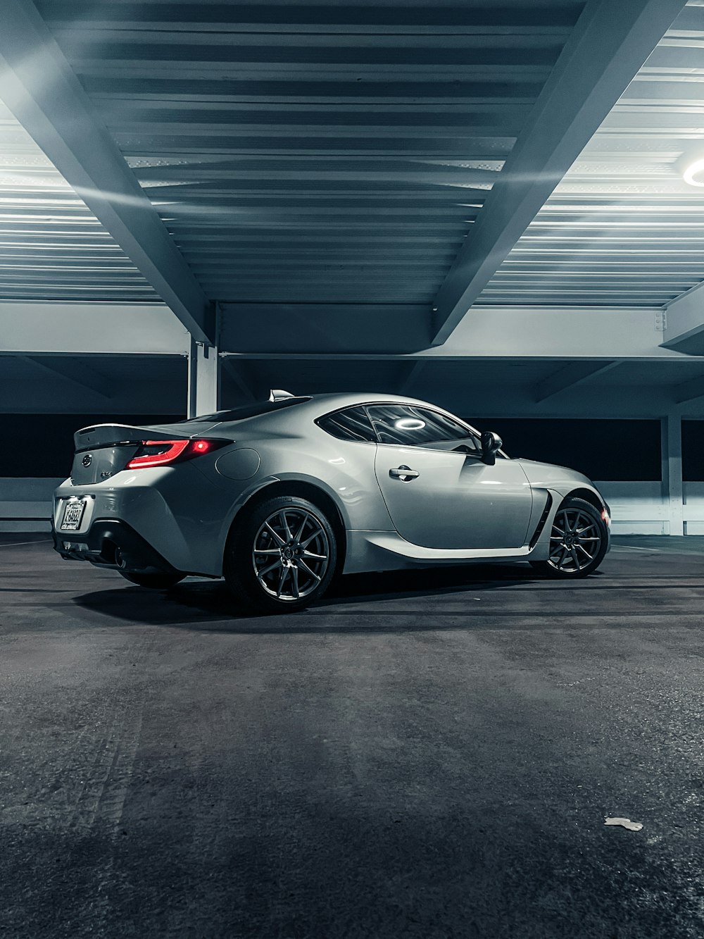 a silver sports car parked in a parking garage