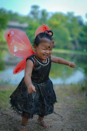 A joyful child playing outdoors dressed in timeless, comfortable littlefrog clothing with natural colors.