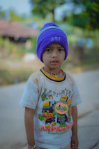 Children wearing cartoon-themed caps playing in a sunny park.