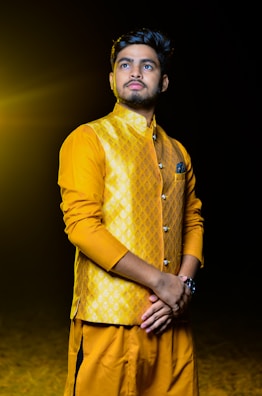 Intricate patterns on a mustard yellow kurta highlighted by soft natural lighting.