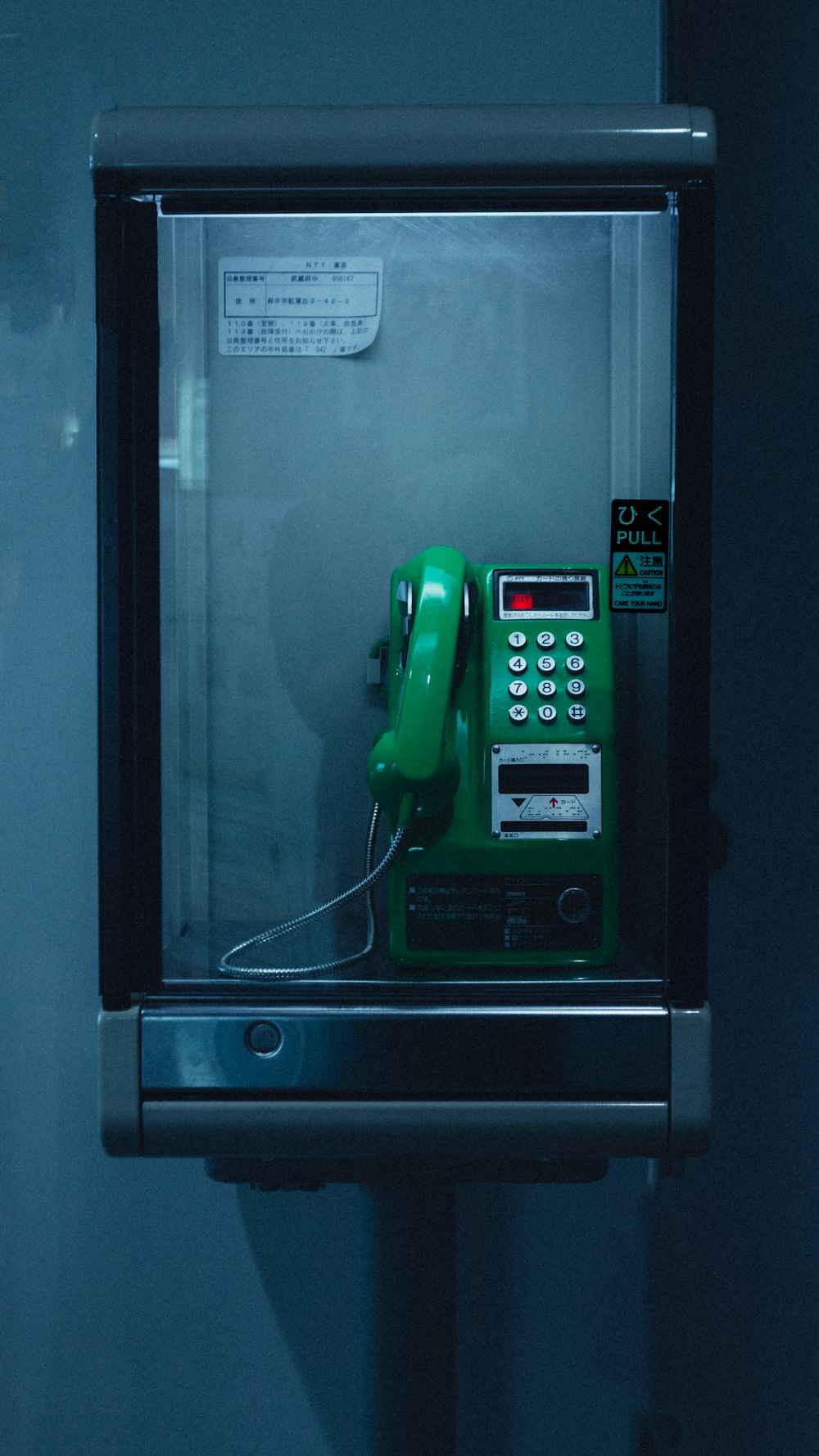 a green phone sitting on top of a metal box