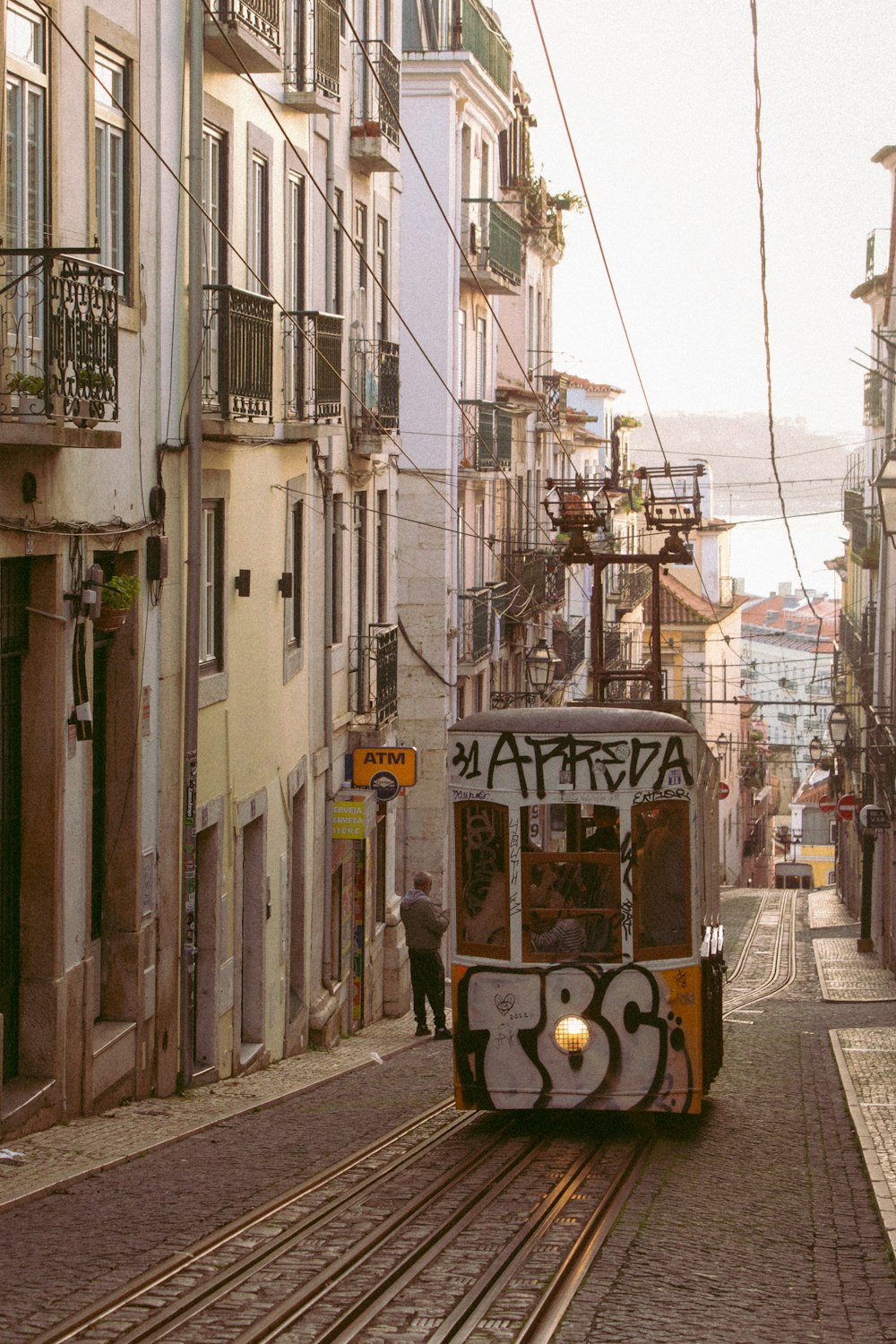 a trolley car with graffiti on the side of a street