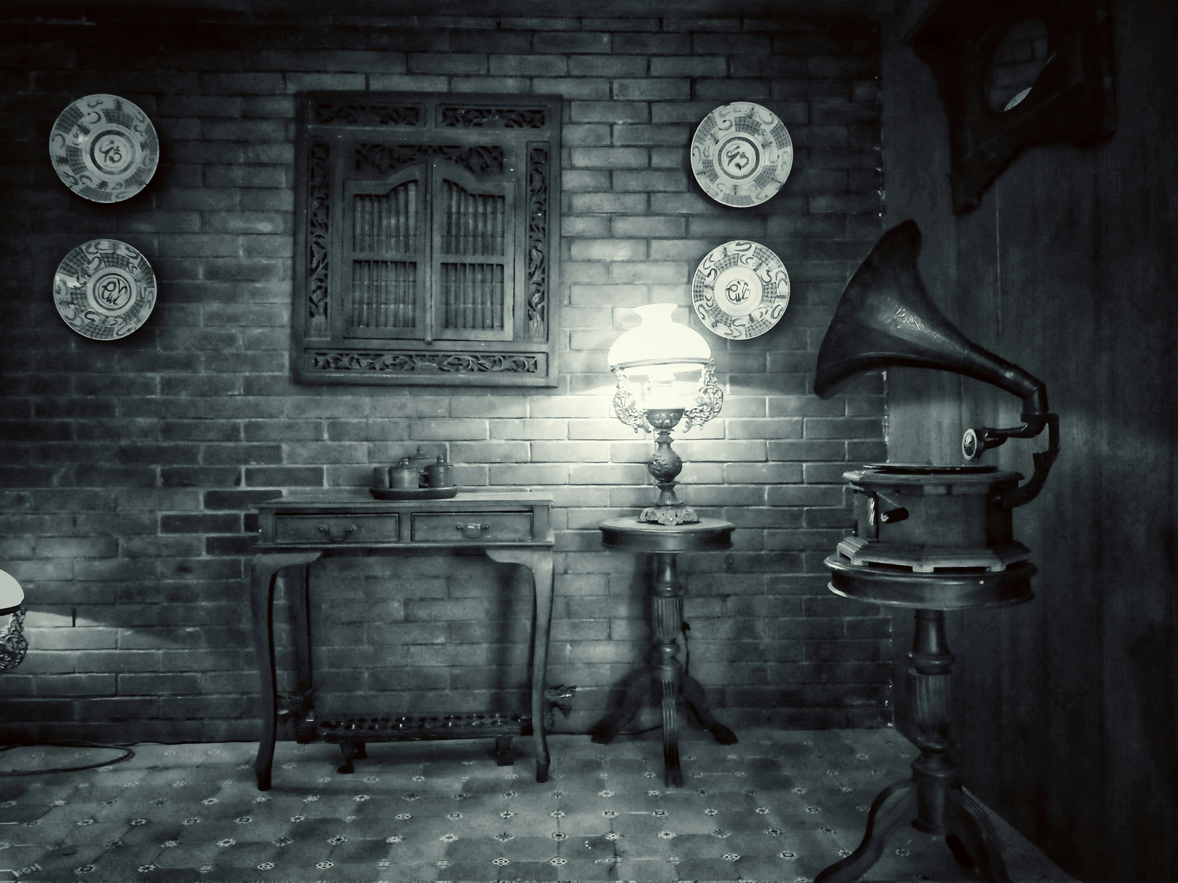 a black and white photo of a room with plates on the wall