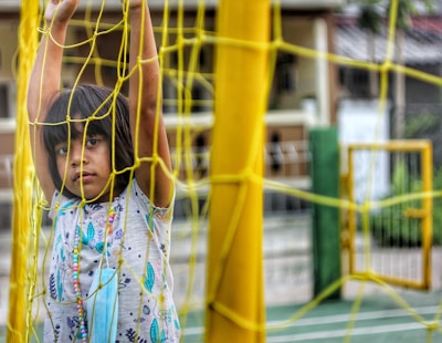 A child playing safely behind a security net.
