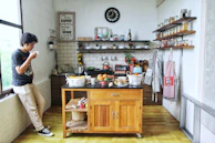 A kitchen scene showing the wooden island topped with fresh herbs and cooking tools.