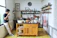 A cozy kitchen featuring a wooden island with natural grain and a bamboo dish rack beside the sink.