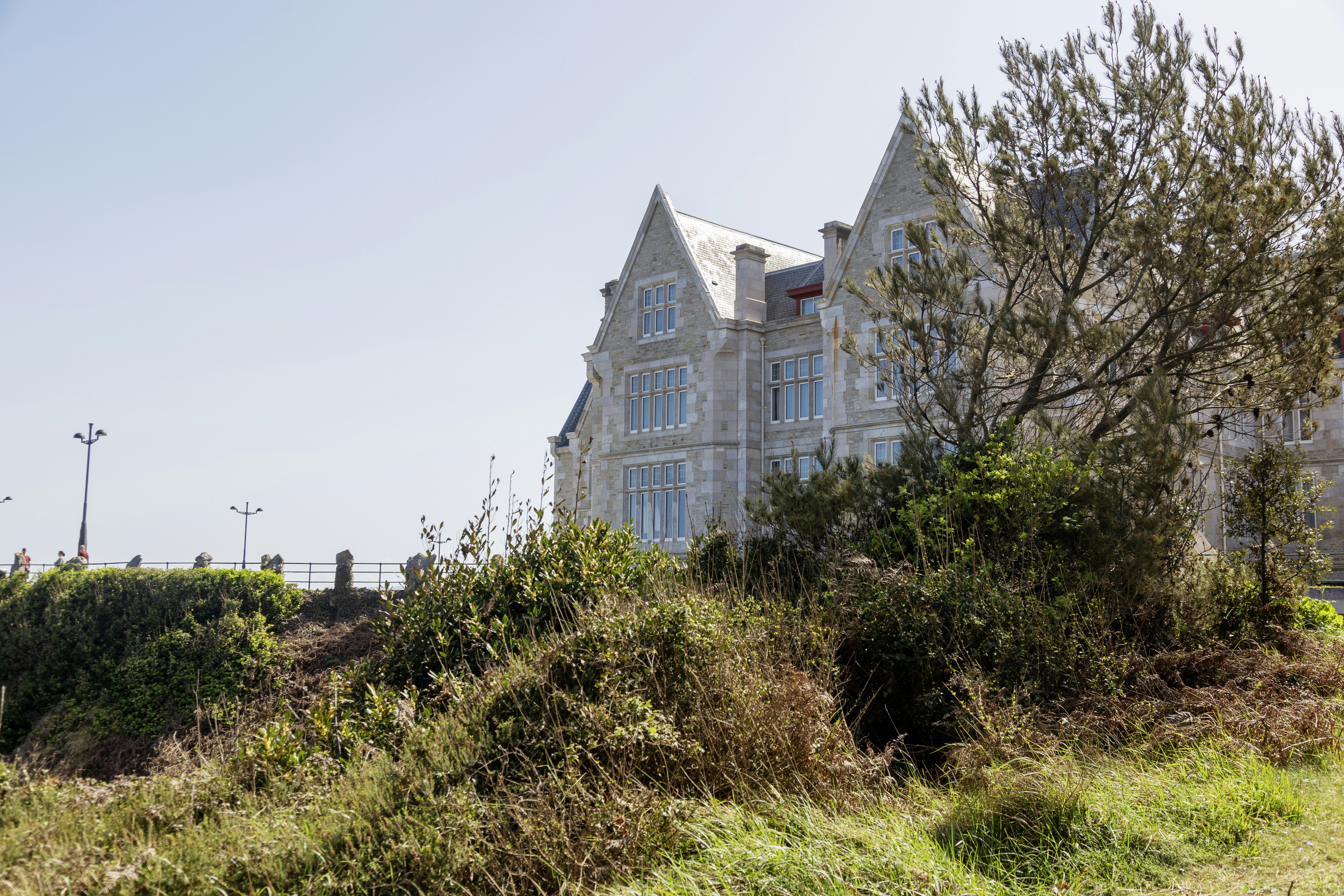 a large white house sitting on top of a lush green hillside