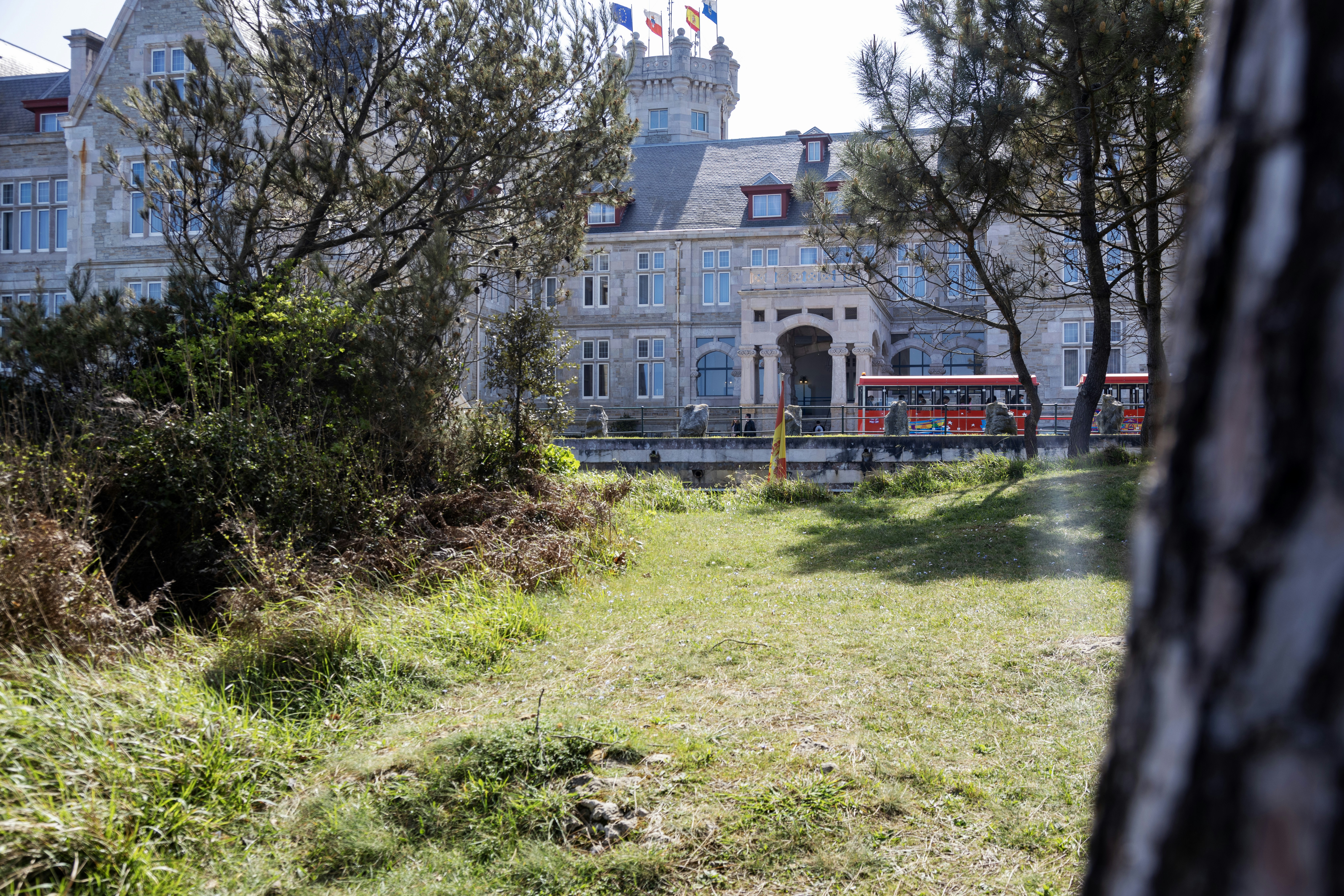 a red double decker bus parked in front of a large building, 