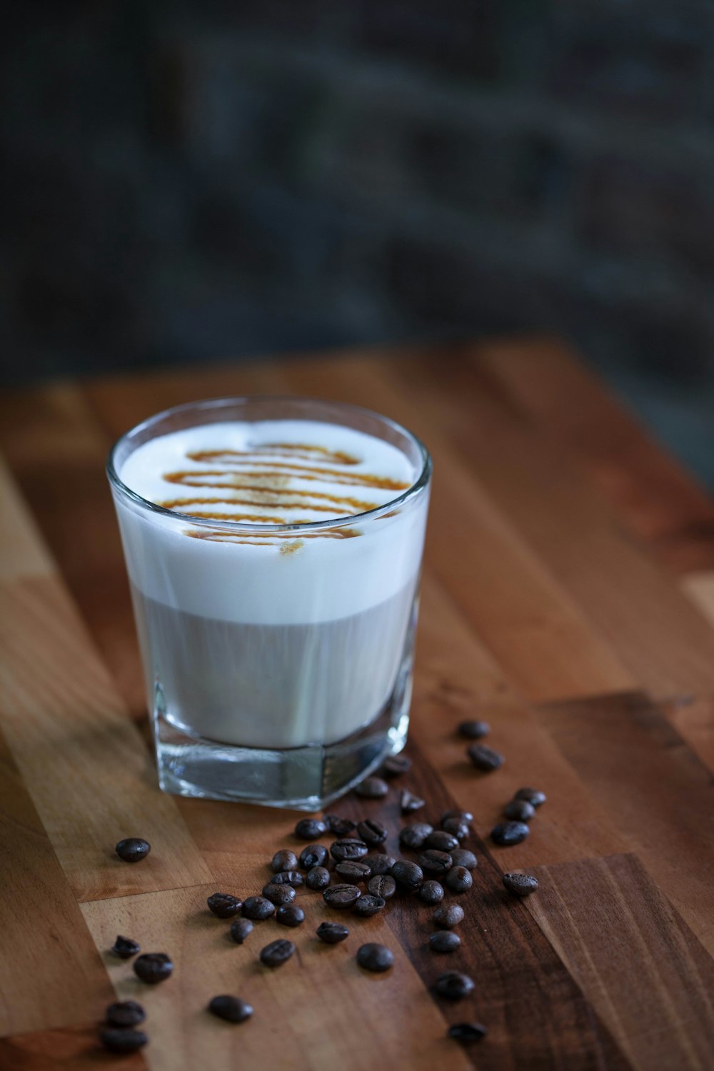 a glass of coffee sitting on top of a wooden table