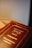 A close-up view of a book with a red cover featuring gold embossed Hebrew text. The book is positioned at an angle, with soft lighting creating a warm ambiance.
