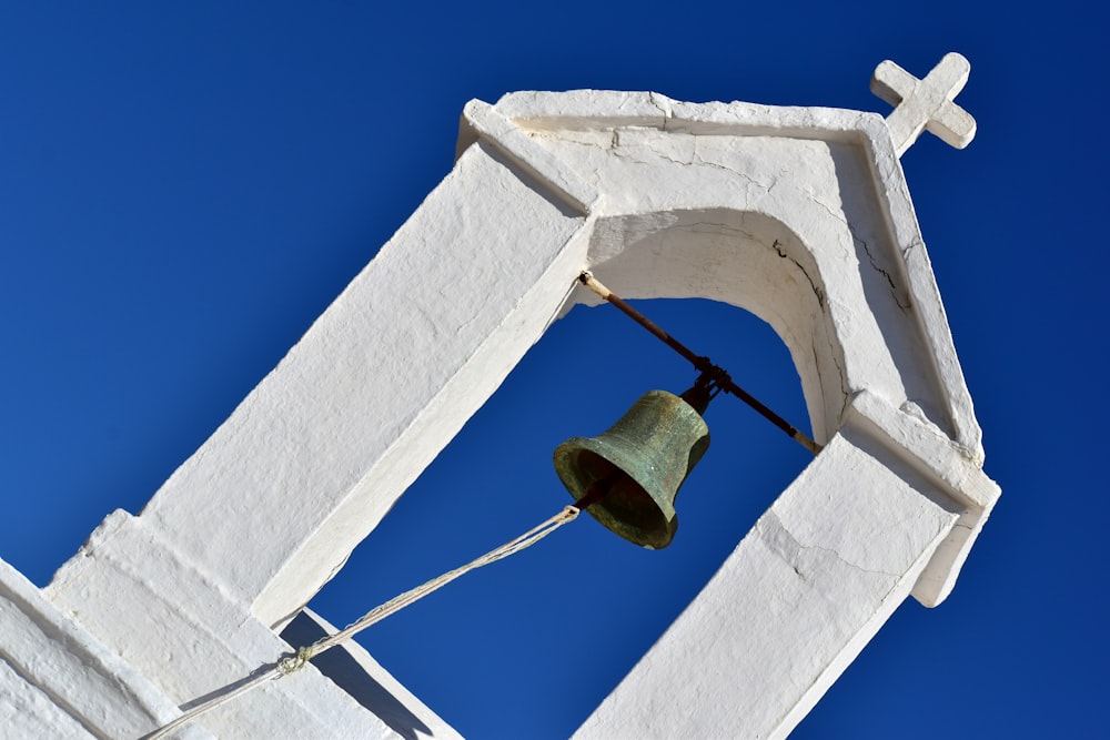 une cloche sur le côté d’un bâtiment blanc