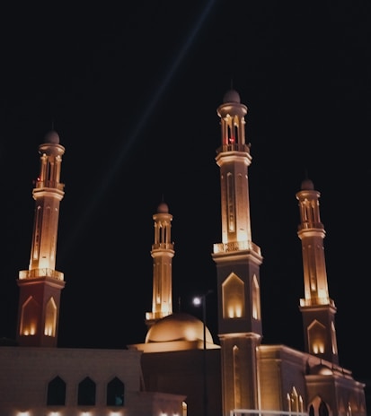 Exterior view of a completed masjid featuring intricate architectural details and elegant lighting.