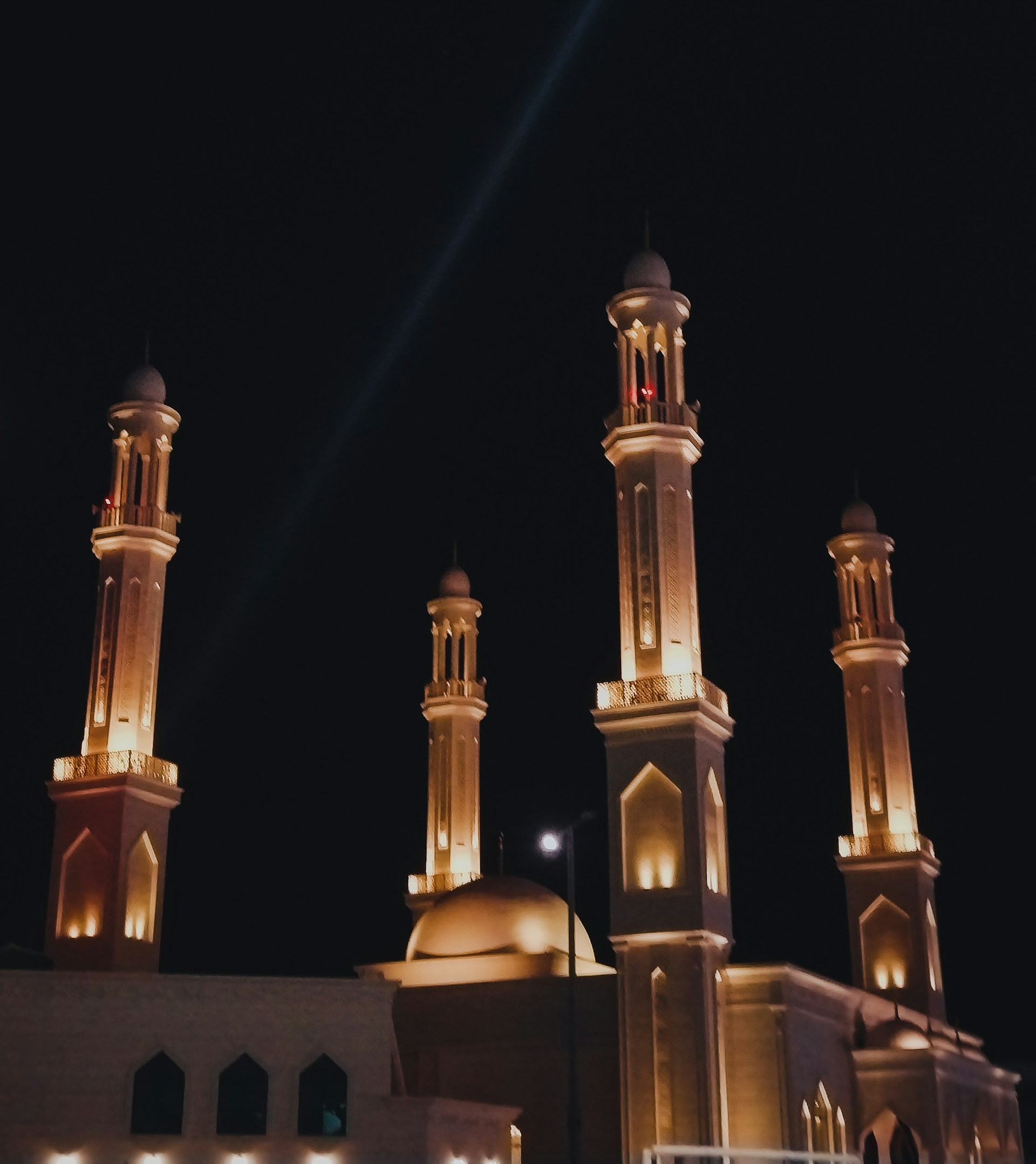 A serene evening shot of the Islamic centre's exterior, softly lit to highlight the elegant architectural details after renovation.