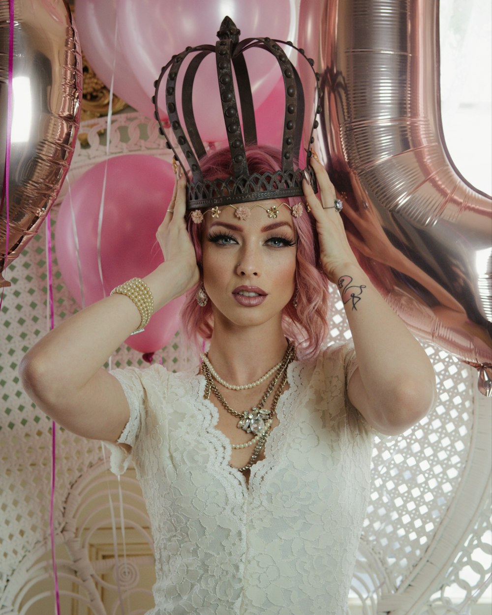 Una mujer con cabello rosado con una corona