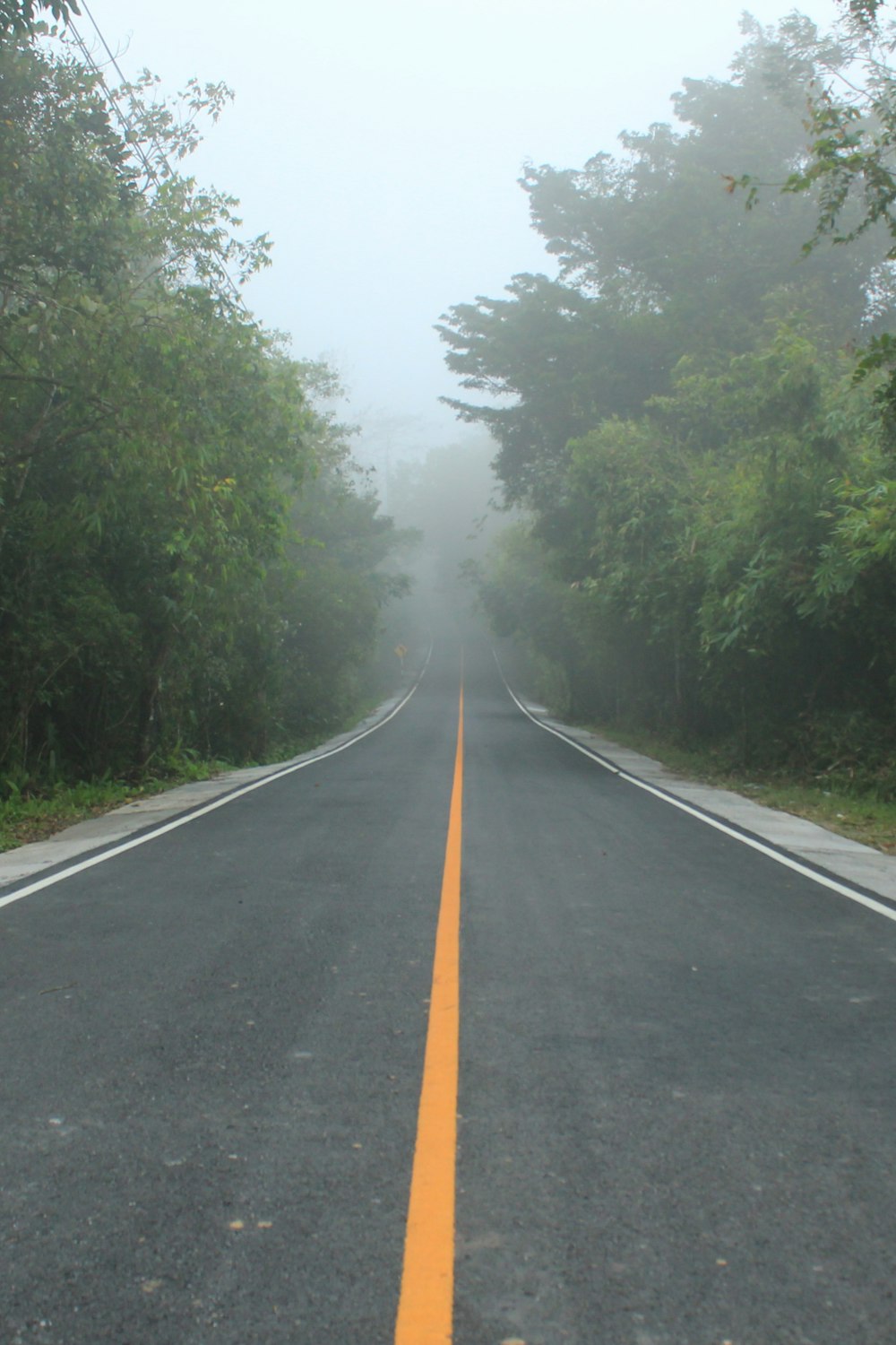 a long road with a yellow line in the middle of it