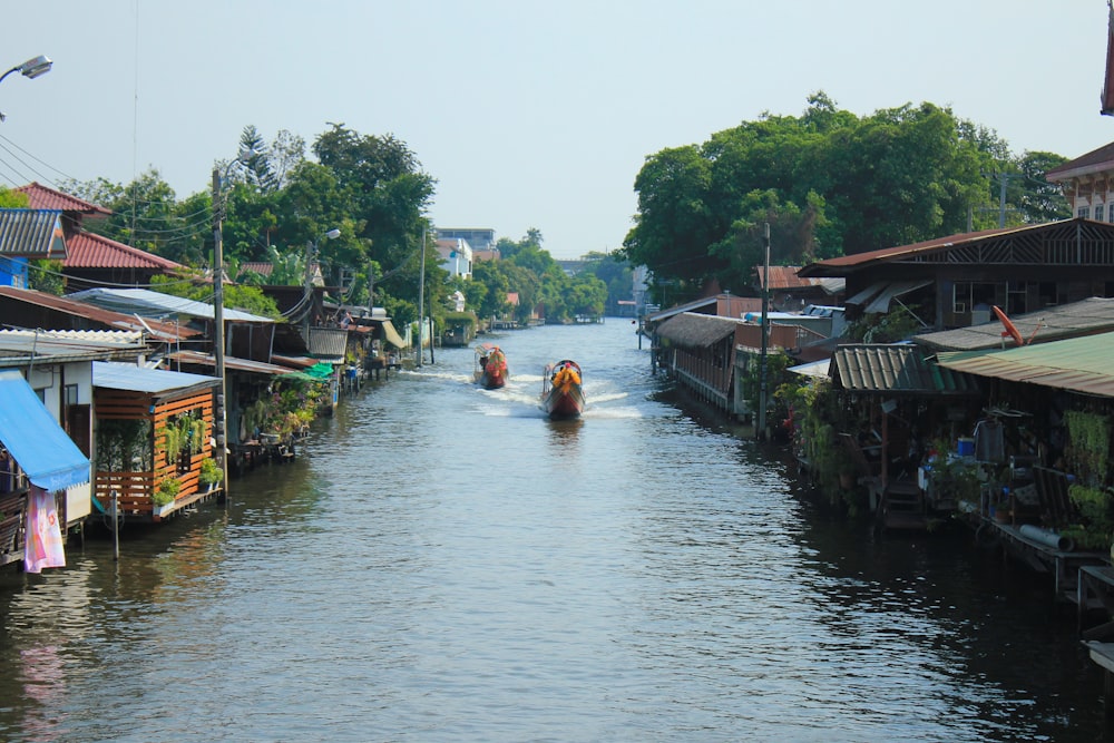 a boat traveling down a river next to houses