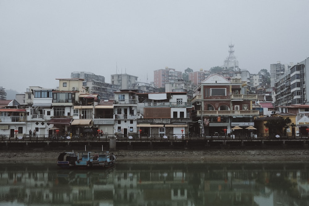 a boat floating on top of a river next to tall buildings