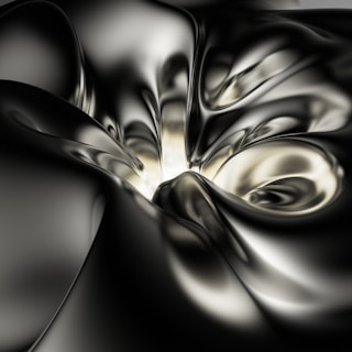 Smooth, metallic surfaces create an abstract pattern with flowing and curving lines, resembling liquid metal or draped silk. The interplay of light and shadow adds depth and a futuristic feel.