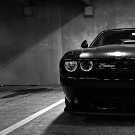 a black and white photo of a car in a parking garage