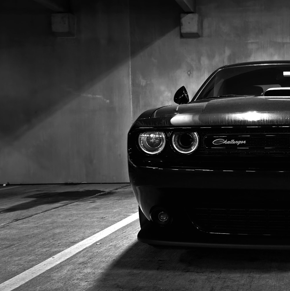 a black and white photo of a car in a parking garage