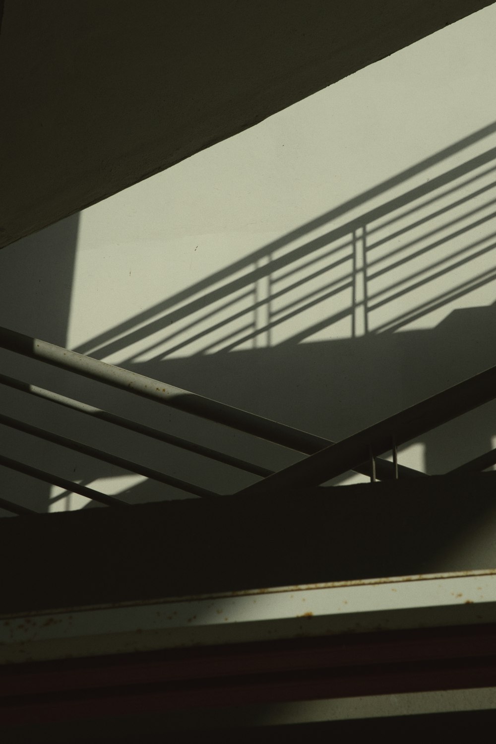 the shadow of a hand rail on a building