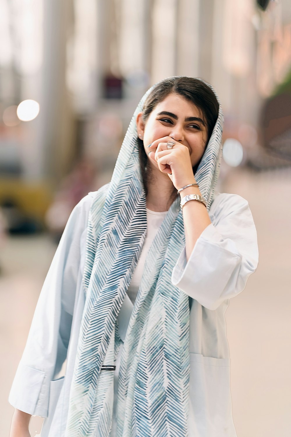 a woman covers her face with a scarf