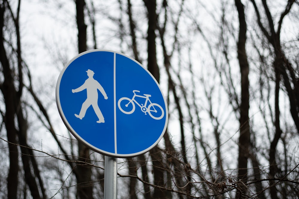 a blue street sign with a man and a bike on it