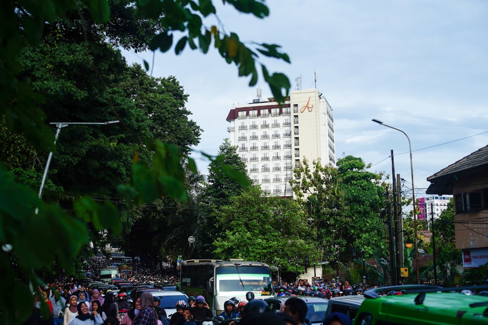 a crowd of people walking down a street next to tall buildings