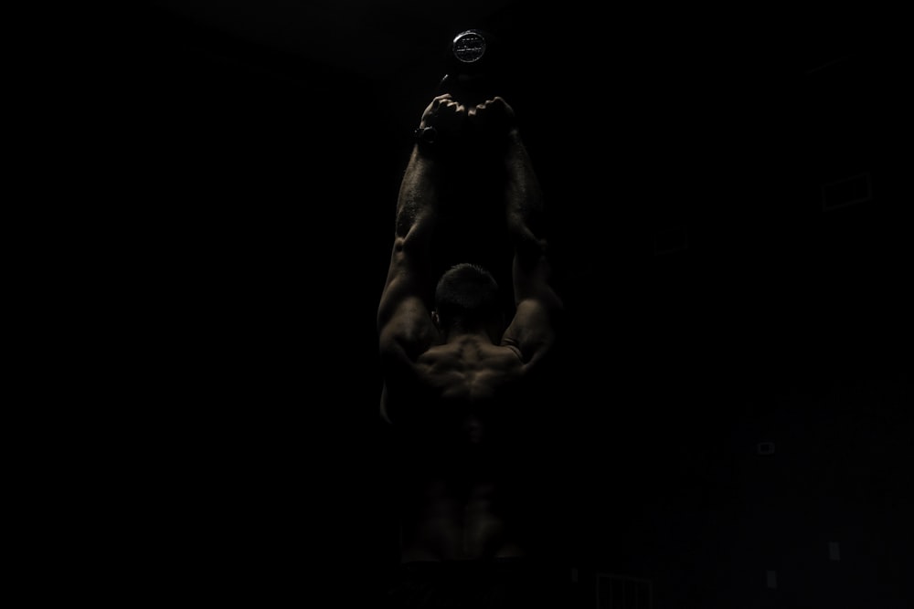 a man hanging upside down in the dark