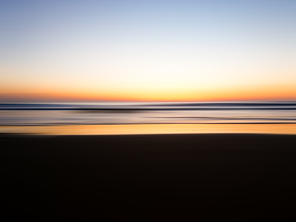 Una foto borrosa de una playa al atardecer