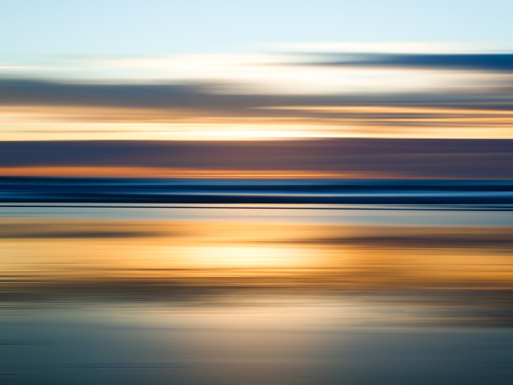 une photo floue d’un coucher de soleil sur l’océan