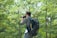 Close-up of a smiling traveler holding a camera in a lush Amazon rainforest setting.