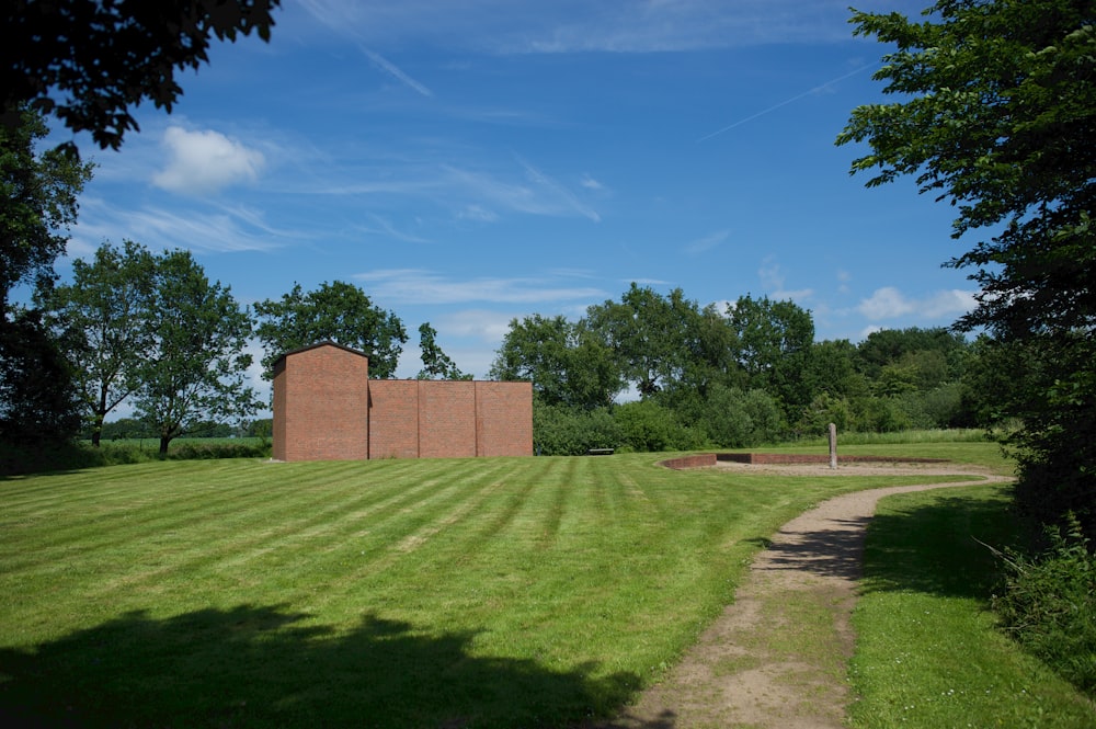 a brick building sitting on top of a lush green field