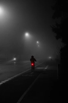 A set of bike lights glowing in the early morning fog