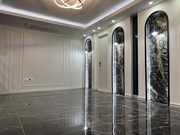 Modern interior featuring gold accents, deep navy blue decor, and a polished marble floor.