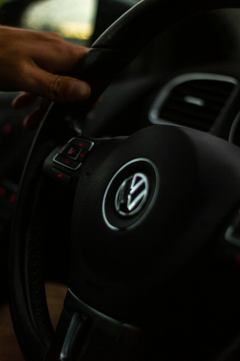 a person holding the steering wheel of a car