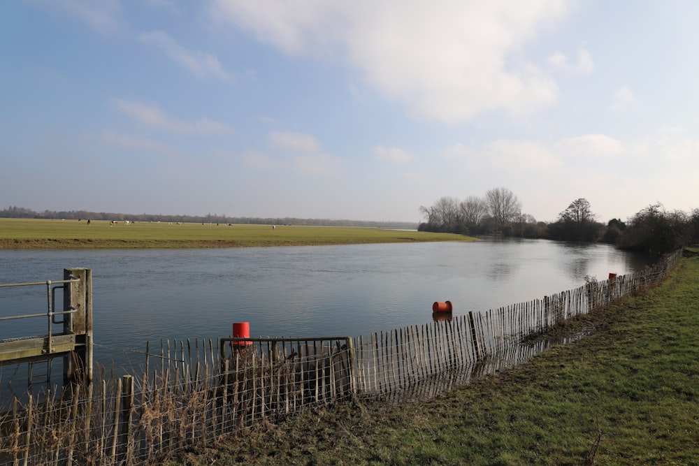 a large body of water next to a wooden fence