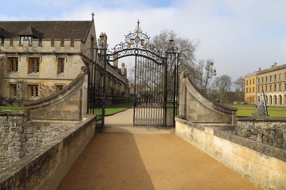 a gated entrance to a castle with a building in the background