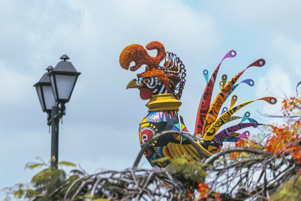 a colorful rooster statue next to a street light