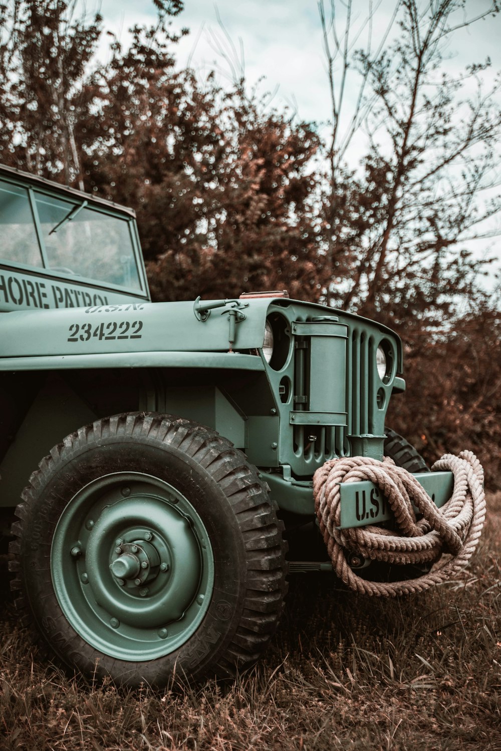 a green jeep parked on top of a grass covered field