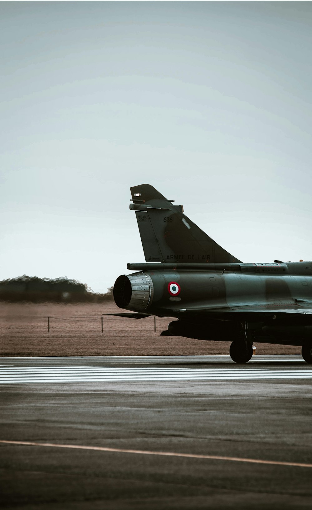 a fighter jet sitting on top of an airport runway