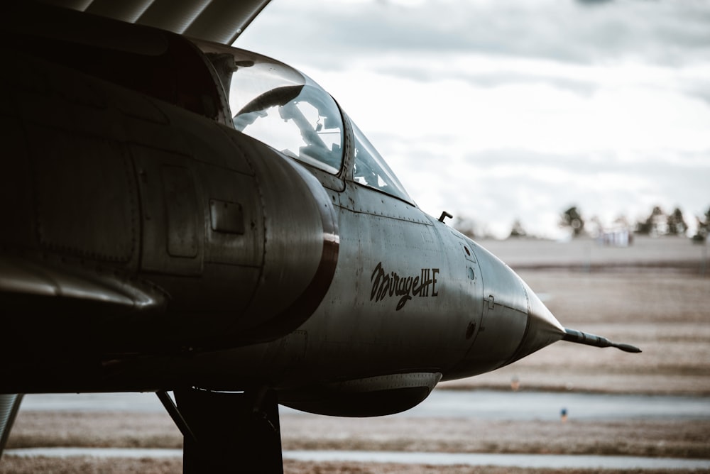 Un avión de combate sentado encima de la pista de un aeropuerto