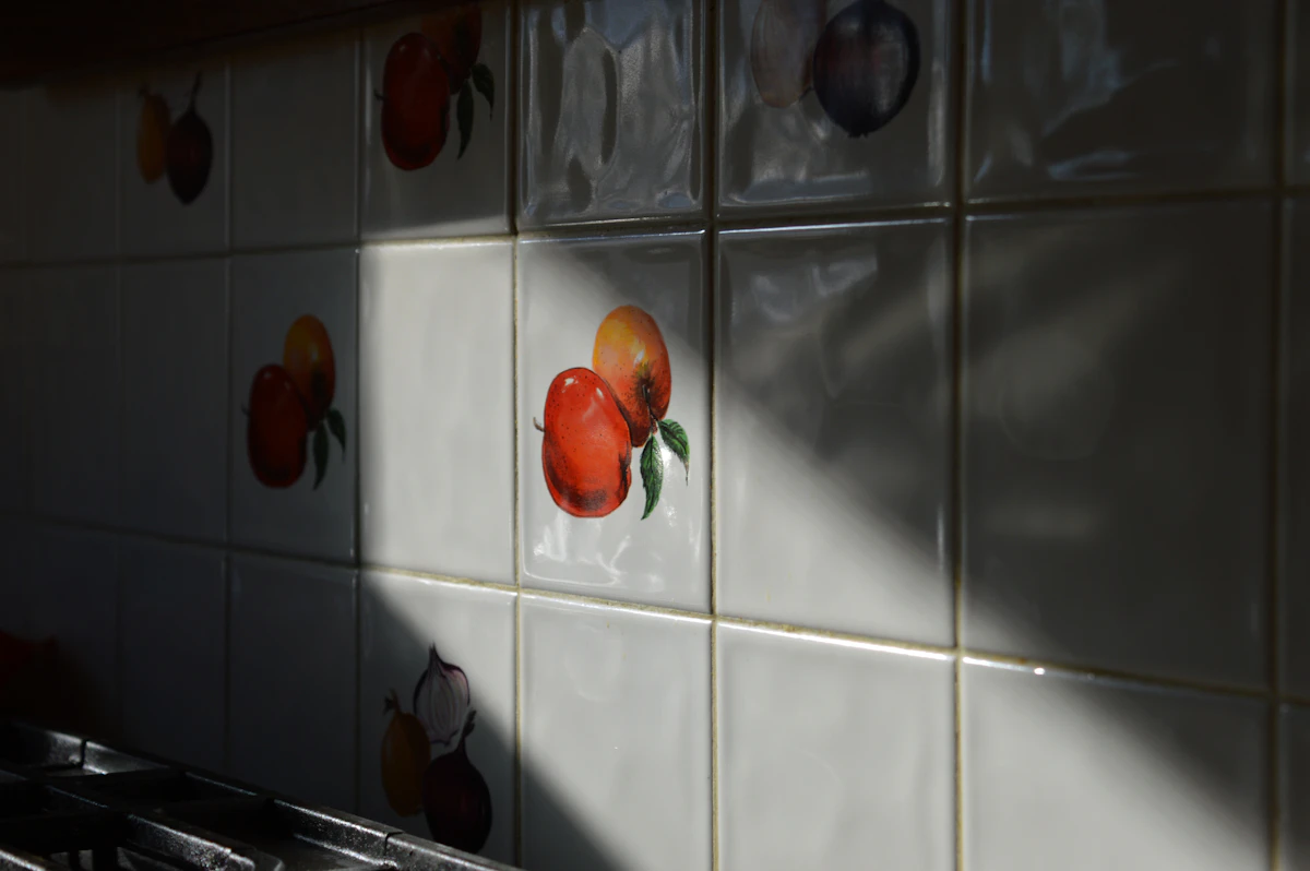 A kitchen with a fully tiled splashback wall.
