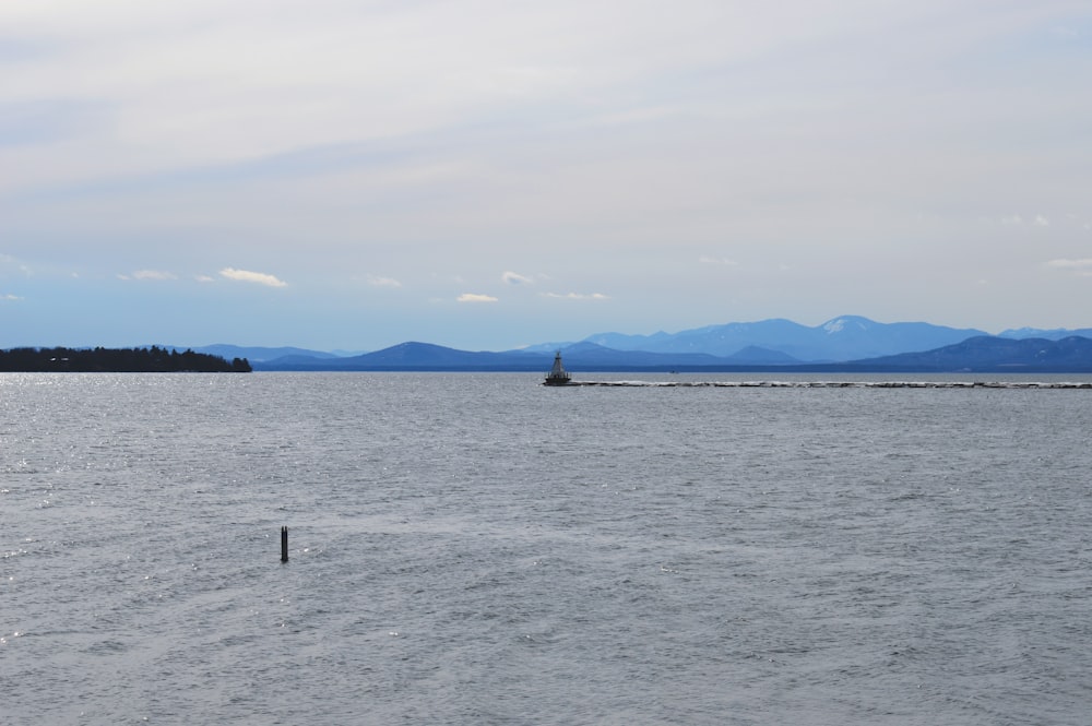 a large body of water with mountains in the background