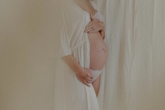 A midwife gently supporting a mother during labor in a village clinic.