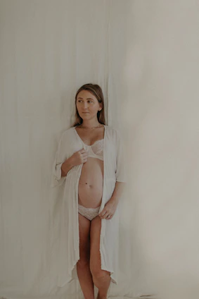 A serene image of a young Indian woman smiling softly, wrapped in a blush pink elegant innerwear set, radiating confidence and comfort.